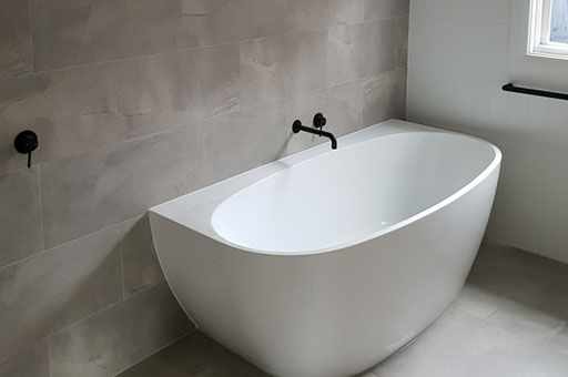 A newly renovated Ipswich bathroom with a contemporary bath and vanity installed into it.